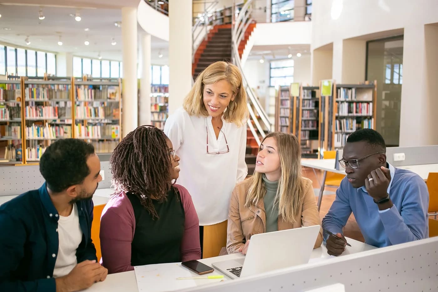Advisor speaking with students in a modern library.