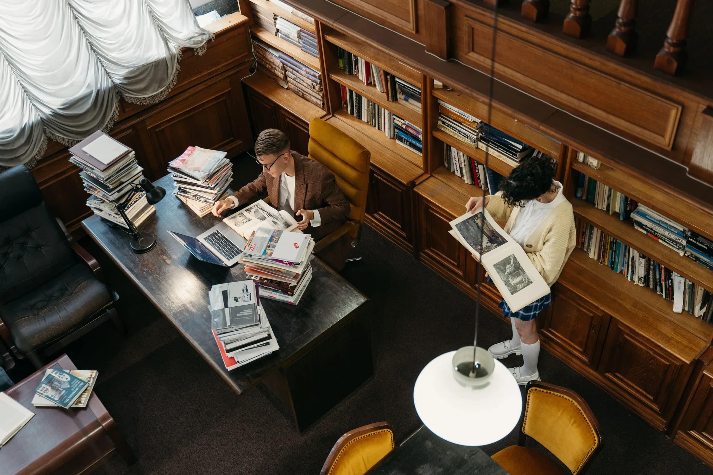 Students studying quietly in a traditional library.